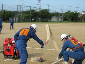 指揮者と1番員によるホース延長の画像