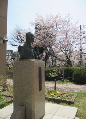 堀田光雄さんの銅像と桜