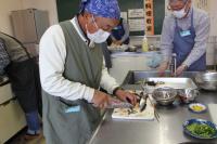 サンマの尾っぽを切り落としている