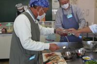 サンマのわたをざるに入れている