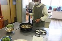 焼いたサンマにたれを入れて煮込んでいる