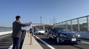 東播磨道の開通記念パレードの様子です。新しい道路を車が走っています。