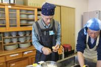 熱々のじゃがいもの皮を剥いている