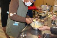 1人の人がカップに生地を入れている