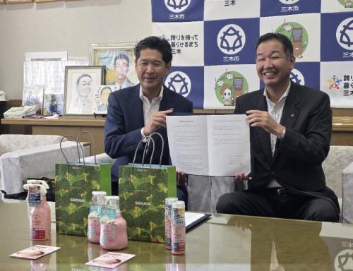 ベビーボックスの製品を前に連携協定書を持つサラヤ株式会社の山田取締役本部長と私