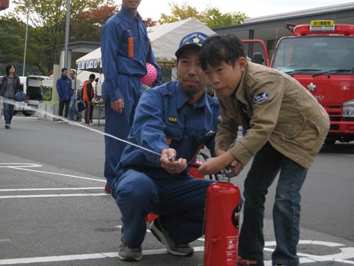 消防団のおじさんと一緒に消火器を放射の画像